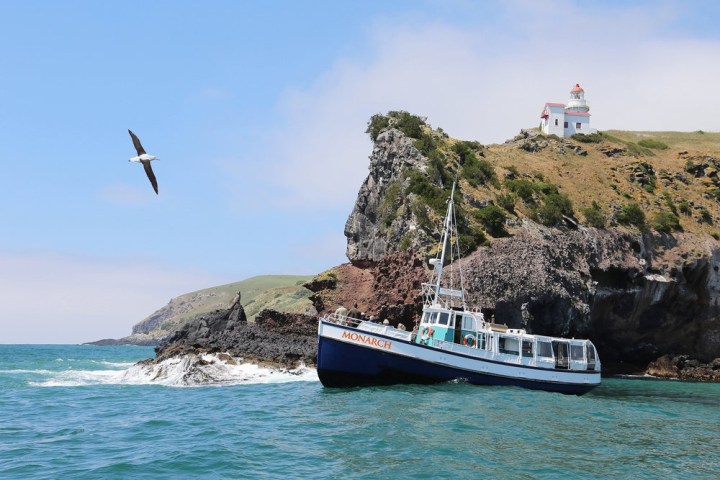 a small boat in a body of water with a mountain in the background